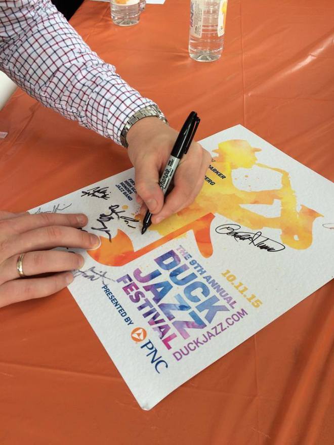 Our trumpeter Paul Rogers signs a Duck Jazz Festival poster, featuring the silhouette of Maceo Parker, the festival headliner.